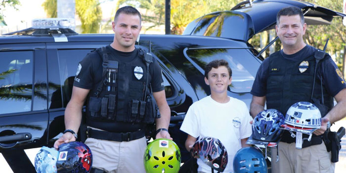 Luca Annunziata hands out helmets with  local Tequesta police deputies